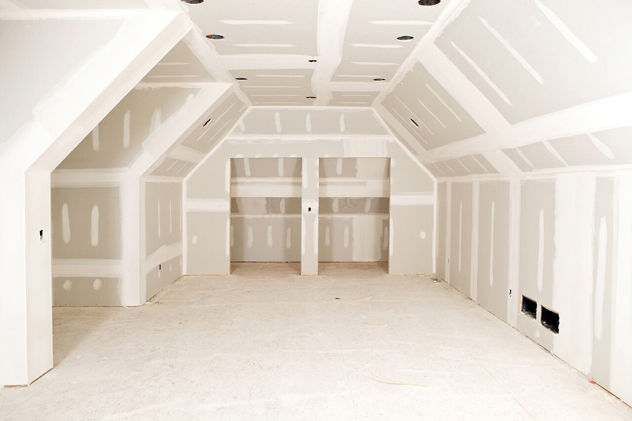 AD Construction NJ - Interior of a room under construction, with drywall installed on walls and ceiling.