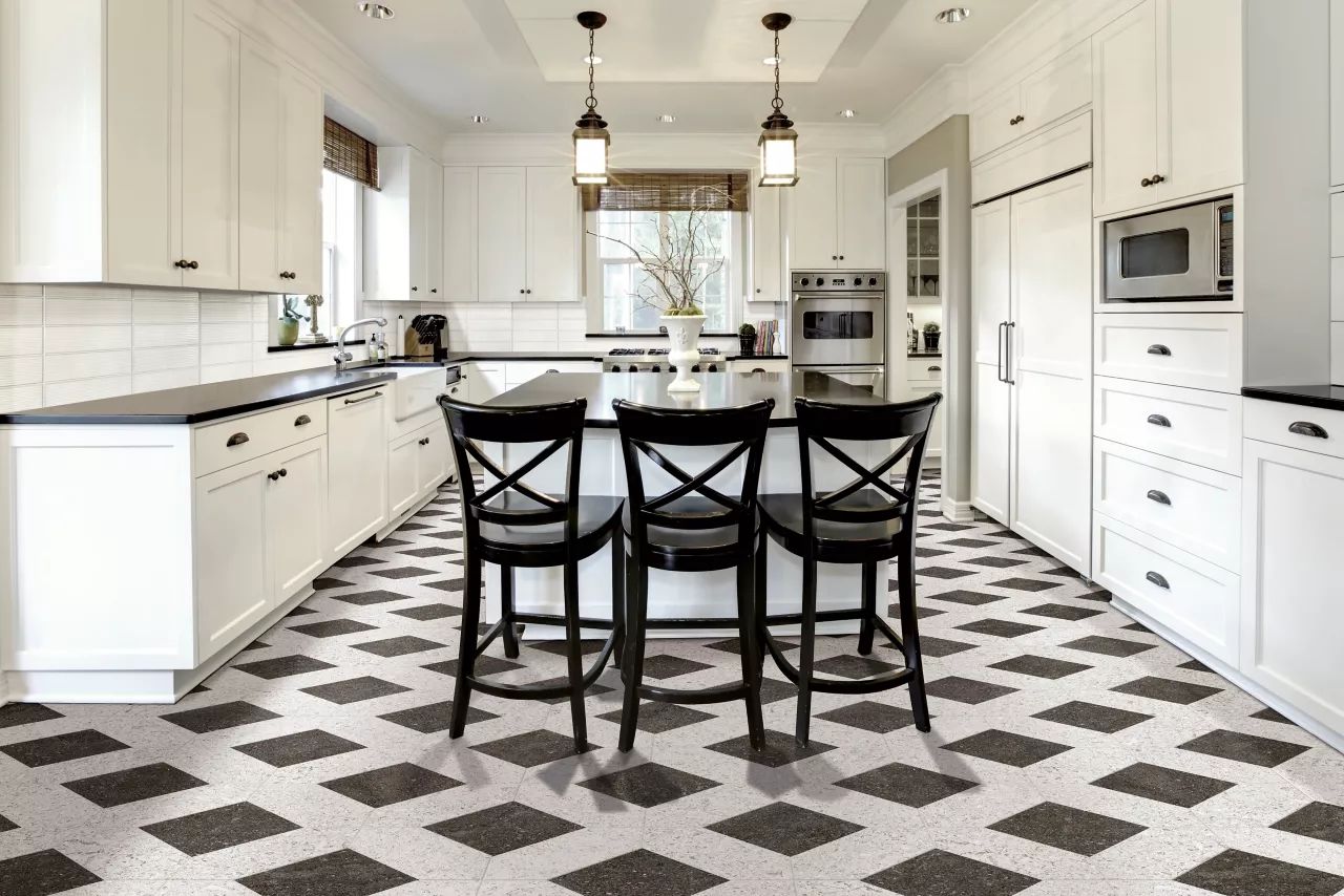 AD Construction NJ - Bright white kitchen with black accents, black and white patterned floor, and three black bar stools.