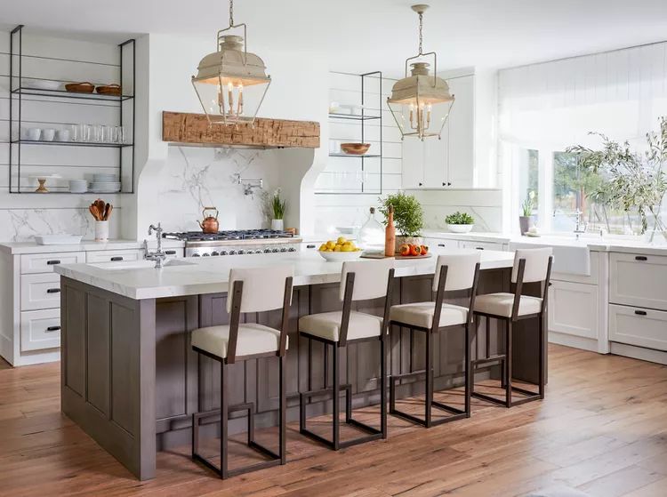 AD Construction NJ - Modern kitchen with island, marble countertops, white cabinets, and bar stools.