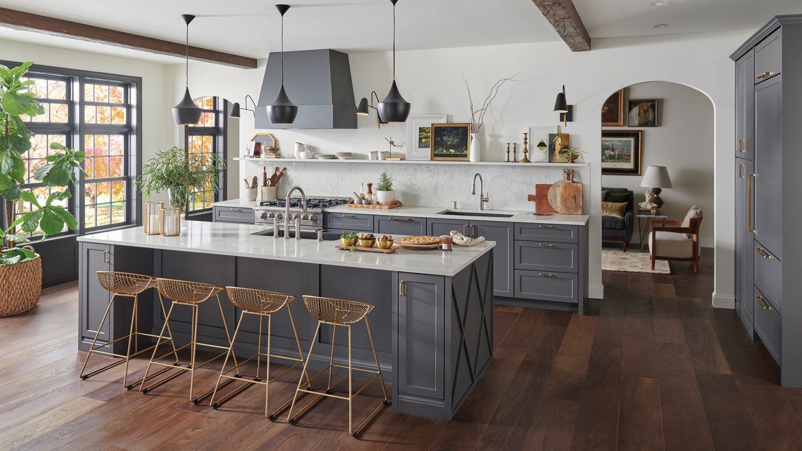 AD Construction NJ - Modern kitchen with gray cabinets, white countertops, island with gold stools, dark wood floors.