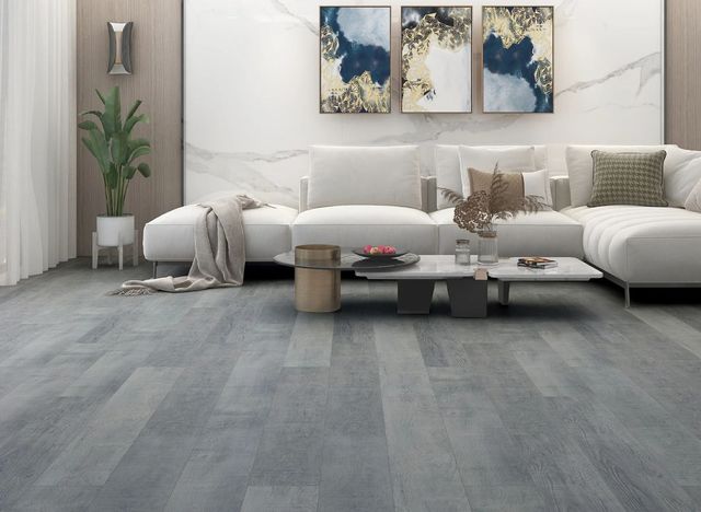 AD Construction NJ - Living room with white sofa, blue abstract art, and gray wood-look flooring.