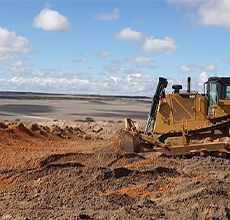 A bulldozer is moving dirt in a field.