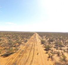 An aerial view of a dirt road in the middle of a desert.