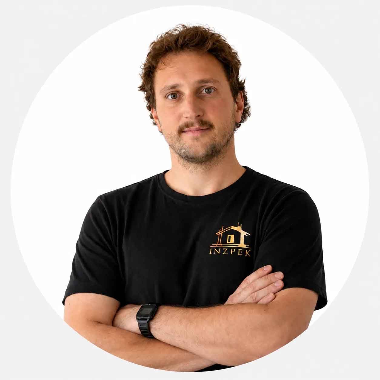 Michael de chez INZPEK, en t-shirt noir à l'effigie de l'entreprise, bras croisés.