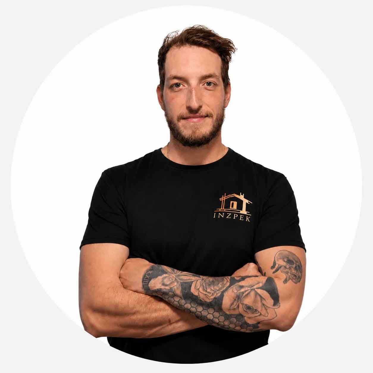 William de chez INZPEK, en t-shirt noir à l'effigie de l'entreprise, bras croisés.