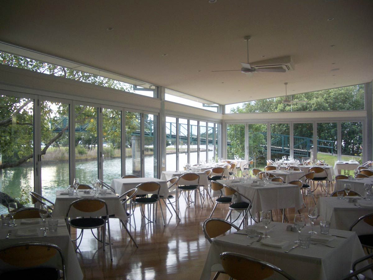 A Restaurant With Tables And Chairs And A View Of The Water — Datco Aluminium Pty Ltd In Murwillumbah, NSW 