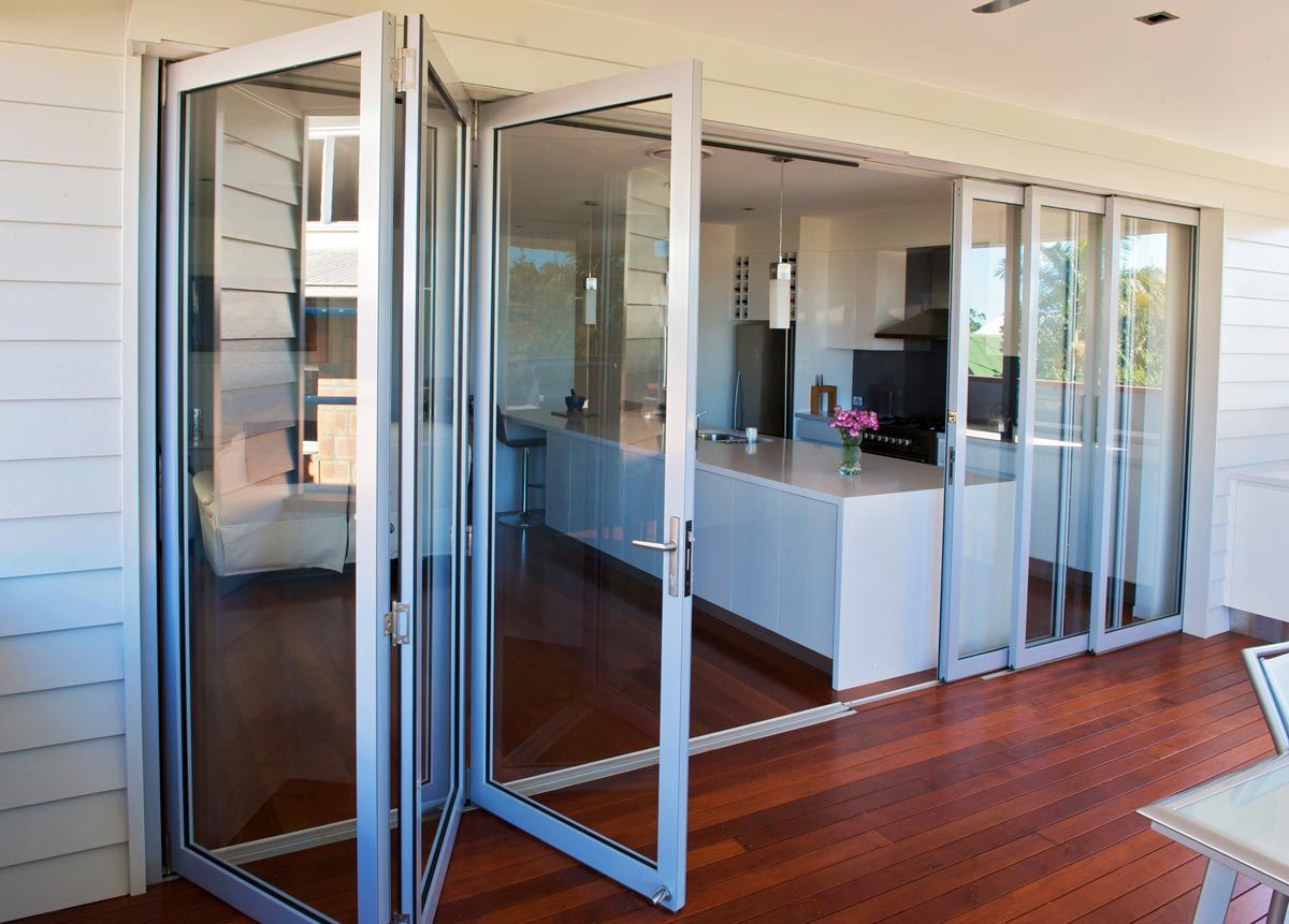 A Kitchen With A Lot Of Glass Doors And A Wooden Floor — Datco Aluminium Pty Ltd In Murwillumbah, NSW