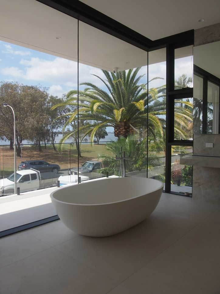 A Bathtub In A Bathroom With A View Of A Palm Tree — Datco Aluminium Pty Ltd In Murwillumbah, NSW 
