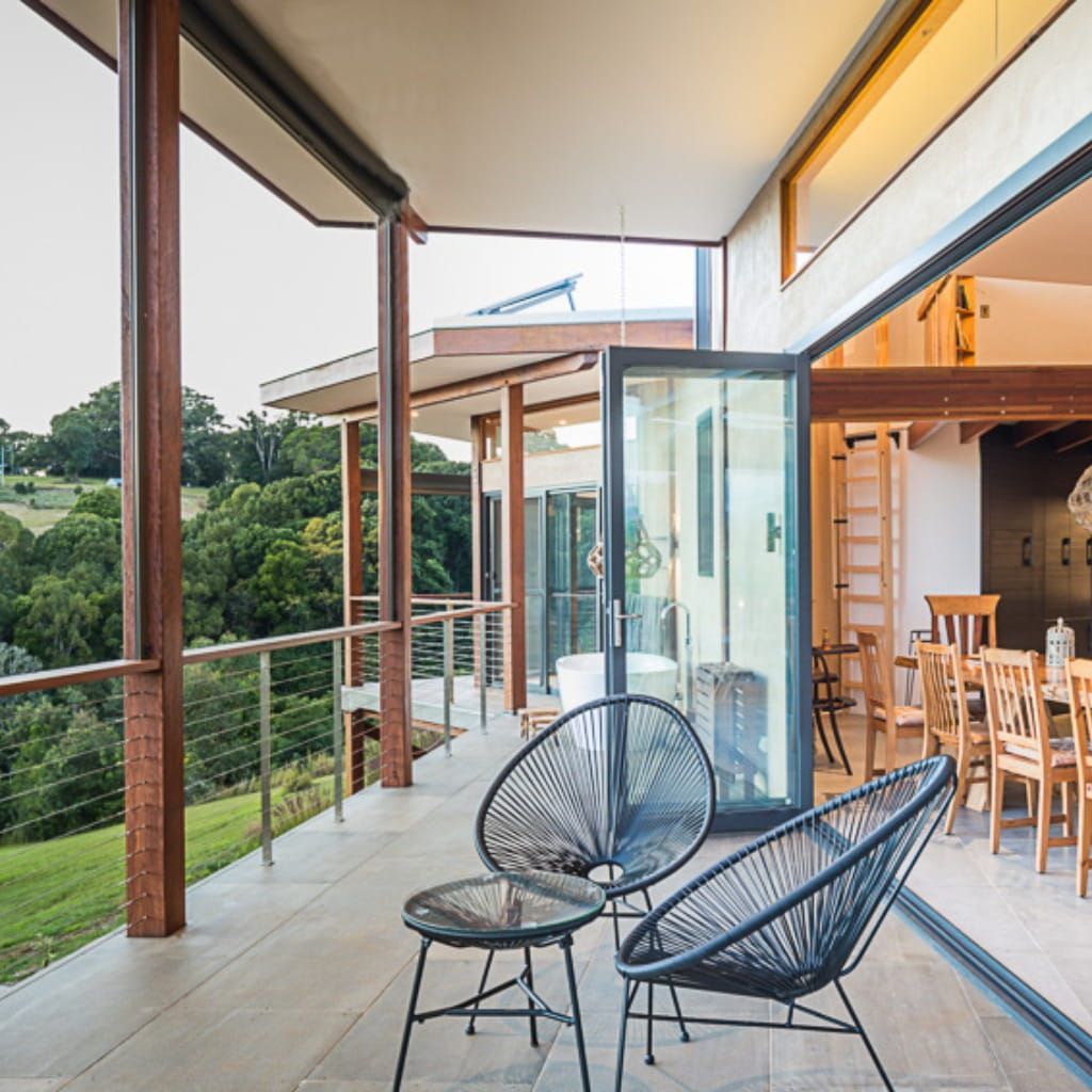 A Balcony With Two Chairs And A Table With A View Of A Forest — Datco Aluminium Pty Ltd In Murwillumbah, NSW 
