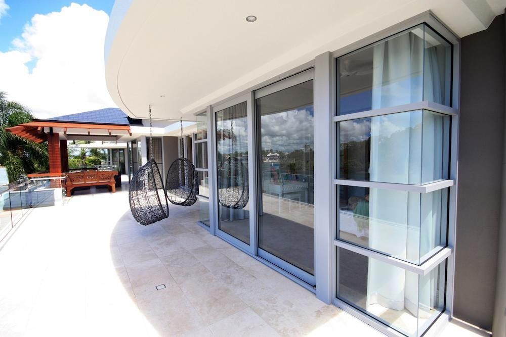 A Balcony With a Lot of Windows and Hanging Chairs — Datco Aluminium Pty Ltd In Murwillumbah, NSW
