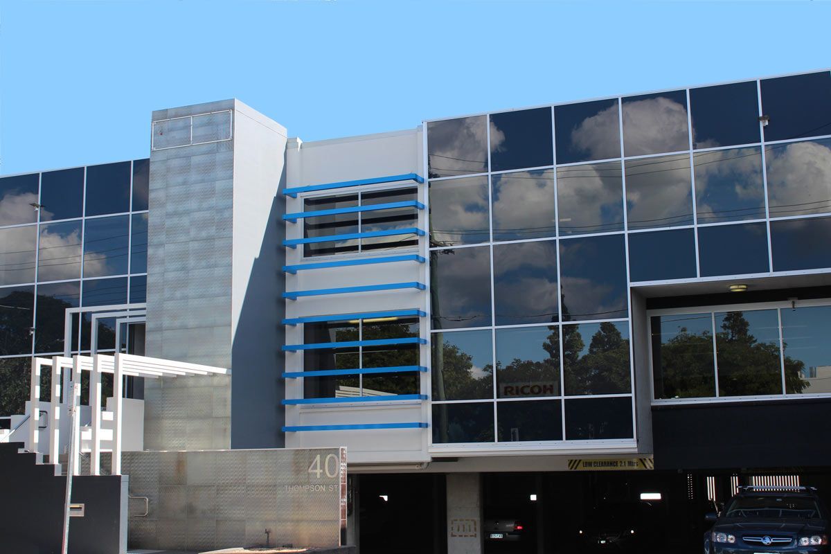 A Large Building With a Lot of Windows and a Car Parked in Front of It — Datco Aluminium Pty Ltd In Murwillumbah, NSW