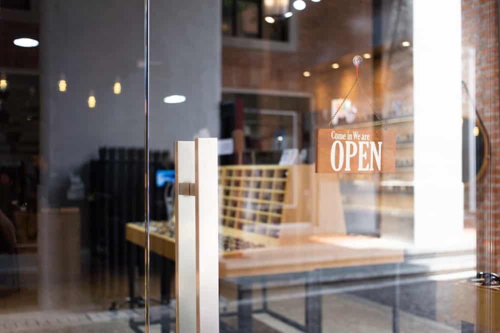 A Glass Door With A Sign On It That Says Open — Datco Aluminium Pty Ltd In Murwillumbah, NSW