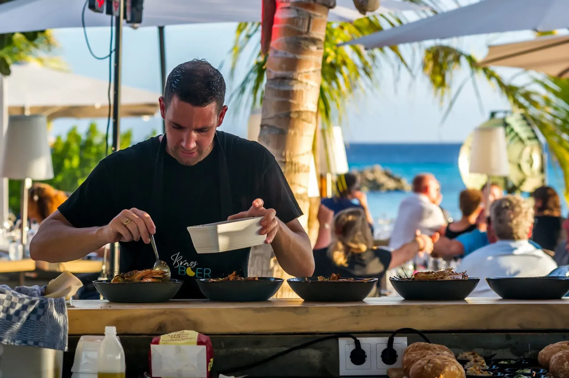 Een man bereidt eten in een restaurant op het strand.