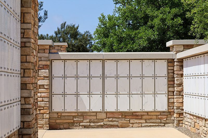 Columbarium: Stone and cream-colored niches for cremated remains in an outdoor setting.