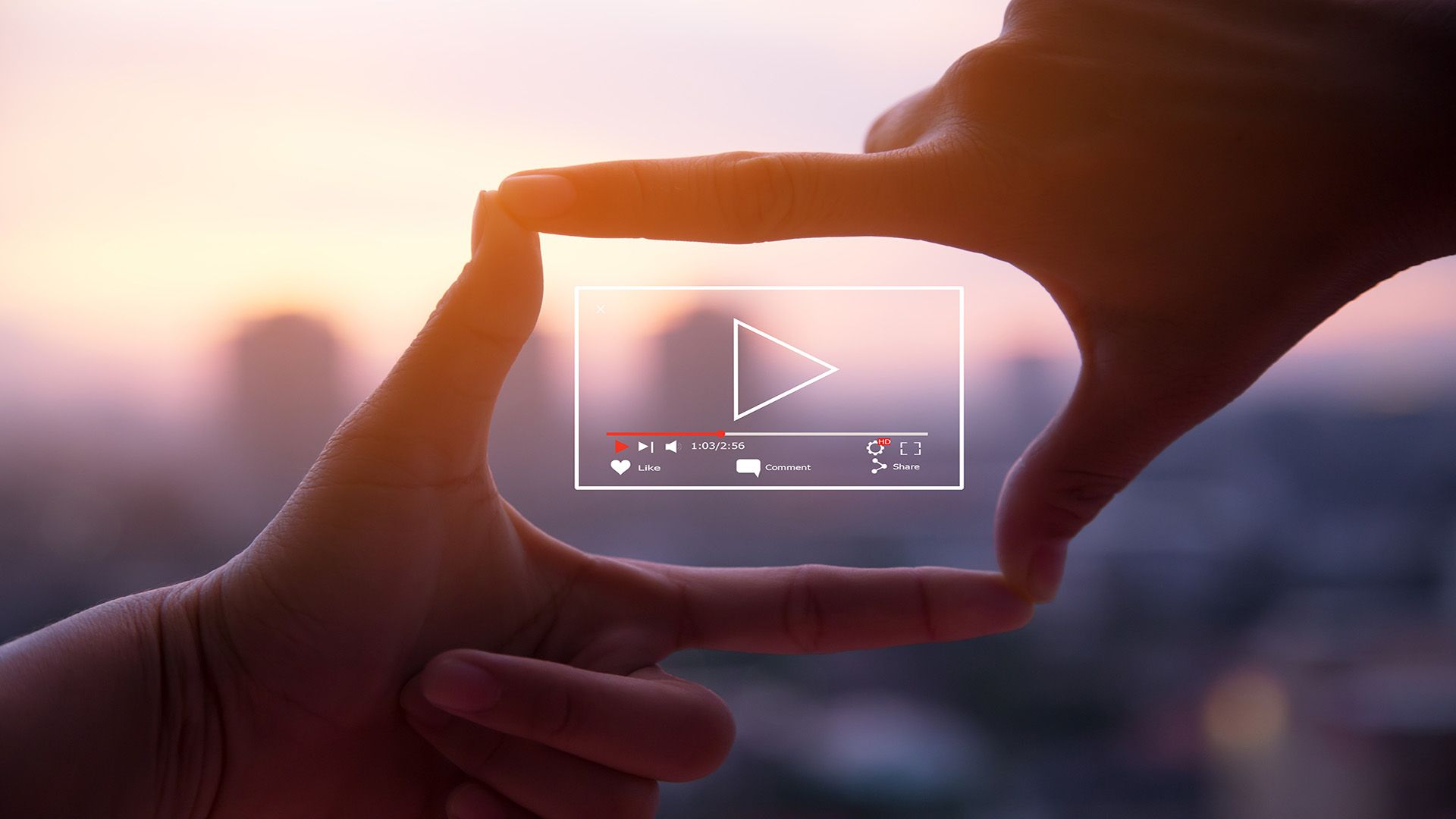 Hands framing a digital video player interface over a blurred cityscape at sunset.