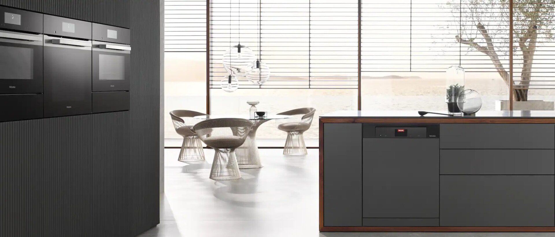 Een keuken met een tafel en stoelen op de achtergrond en een groot raam.