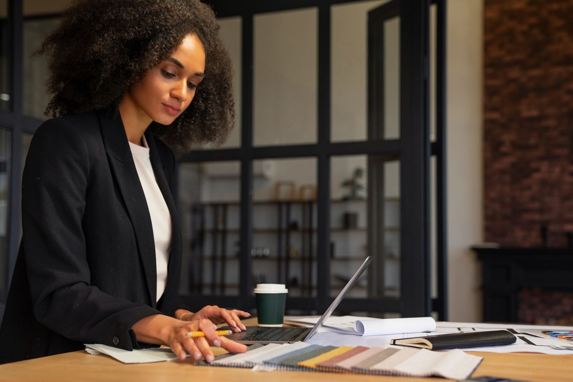 A woman is sitting at a table using a laptop computer.