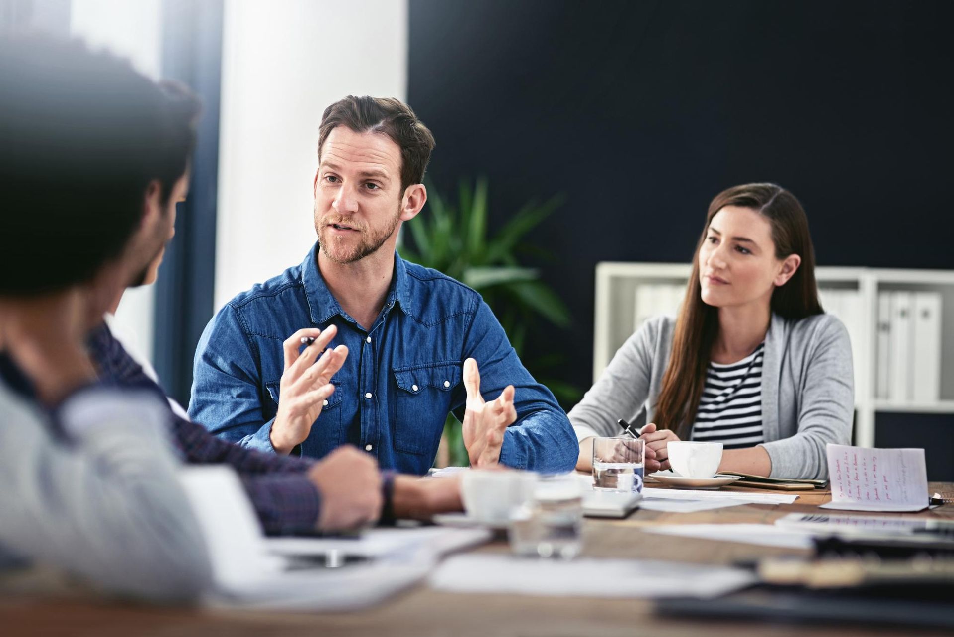 A group of people are sitting around a table having a meeting.