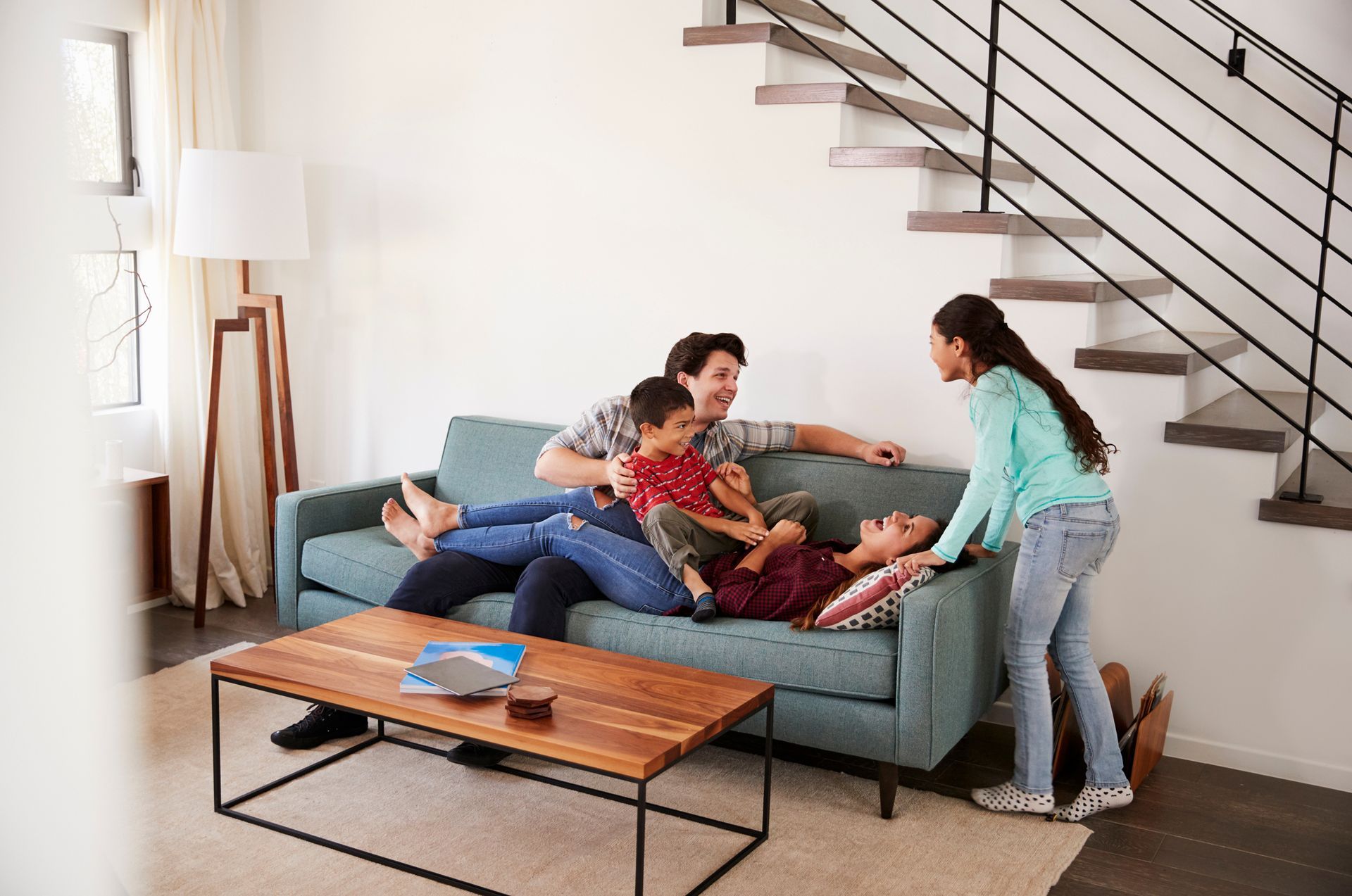 A family is sitting on a couch in a living room.