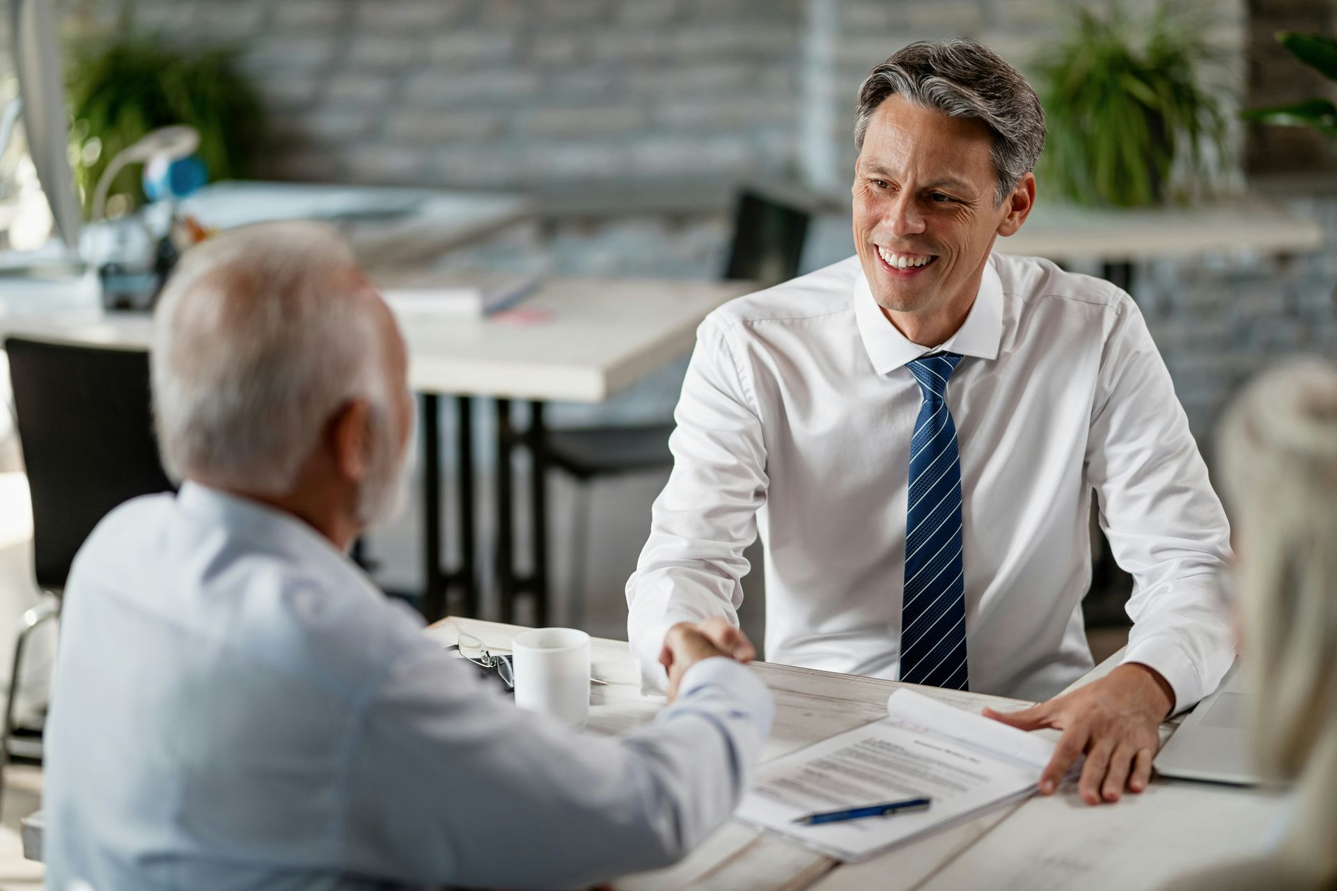 Two men are sitting at a table having a conversation.