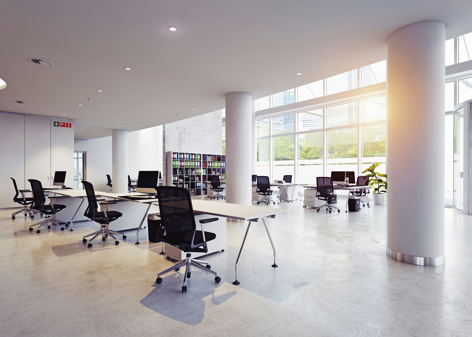 An empty office with a lot of windows and tables and chairs.