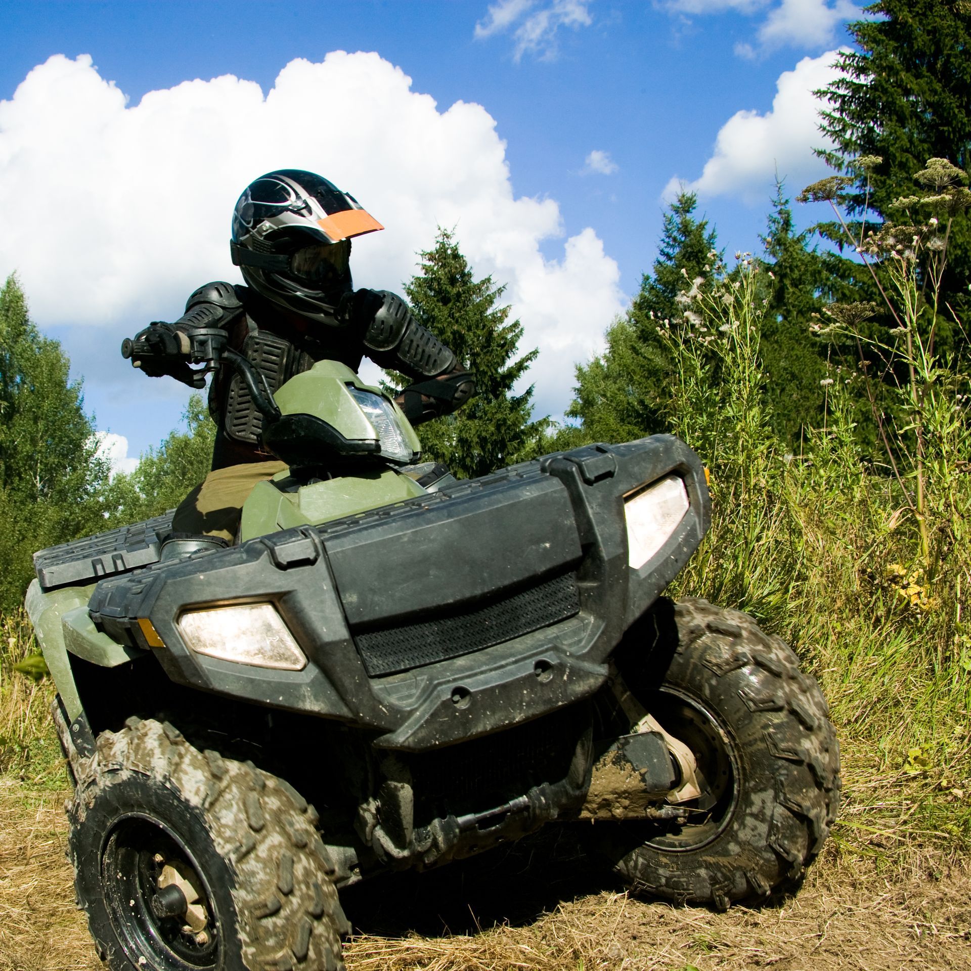A man wearing a helmet is riding an atv
