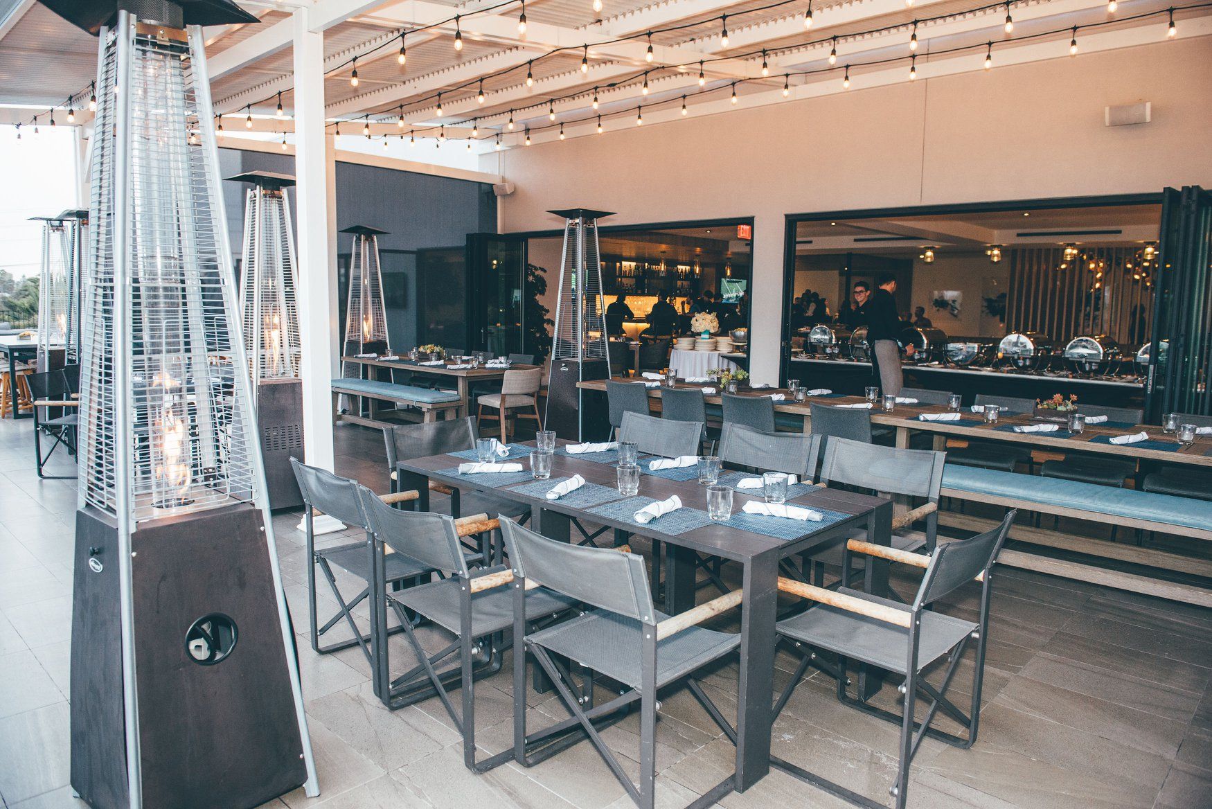 A restaurant with tables and chairs and a heater.