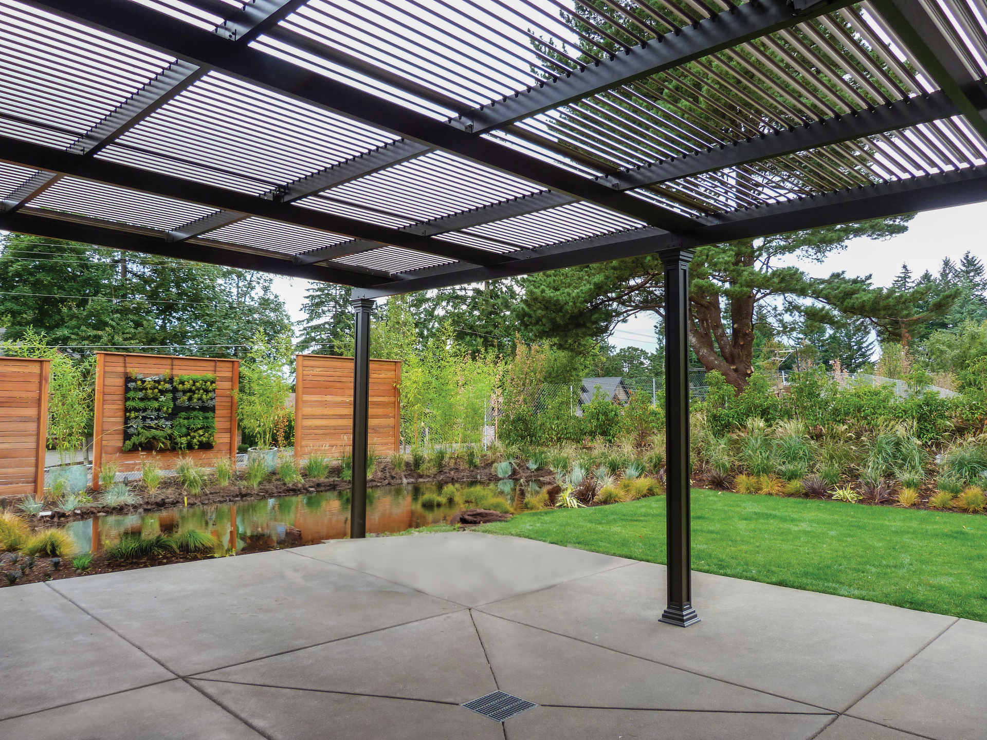 An empty patio with a pergola and trees in the background
