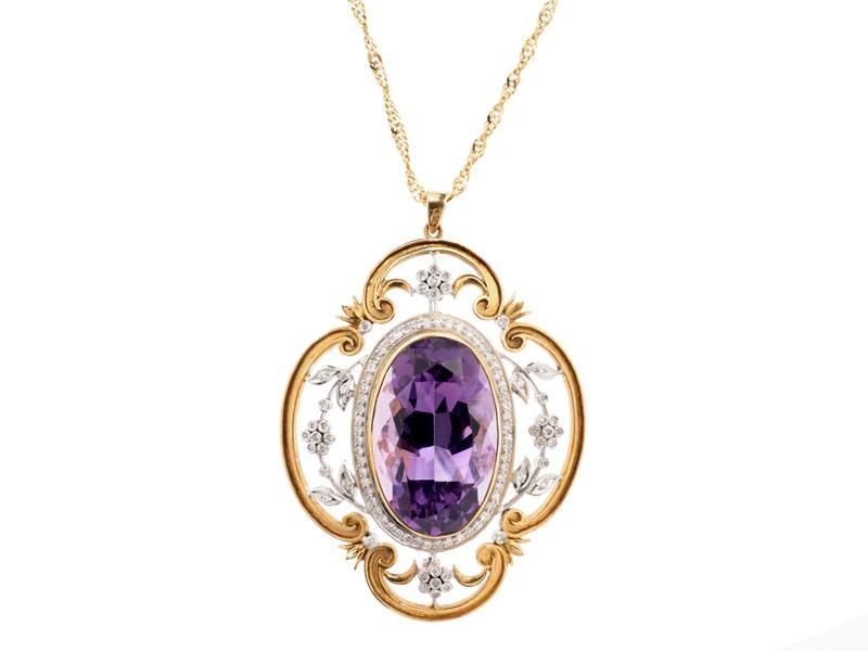 Gold pendant necklace with oval purple gemstone and ornate white filigree frame
