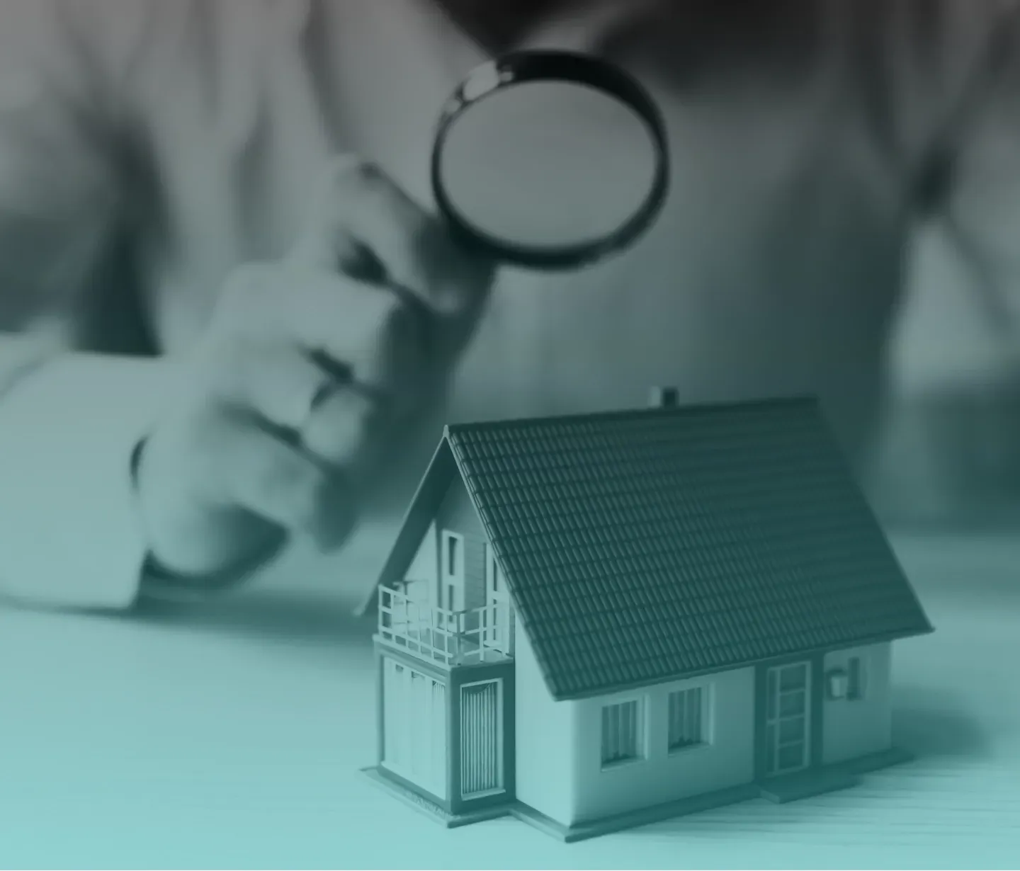 A man is holding a magnifying glass over a model house.