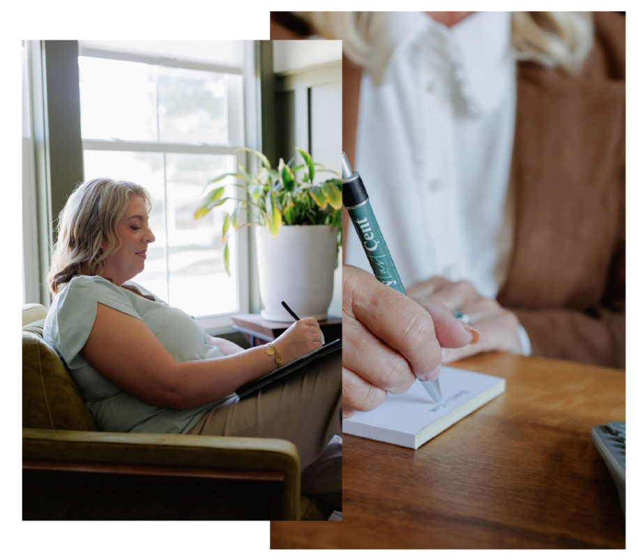 Person writing in a notebook beside a window, with a plant and a stack of books nearby