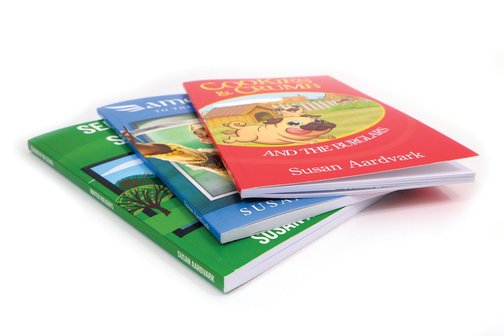 Three colorful children's books stacked. The top book is red, the middle blue, and the bottom green.