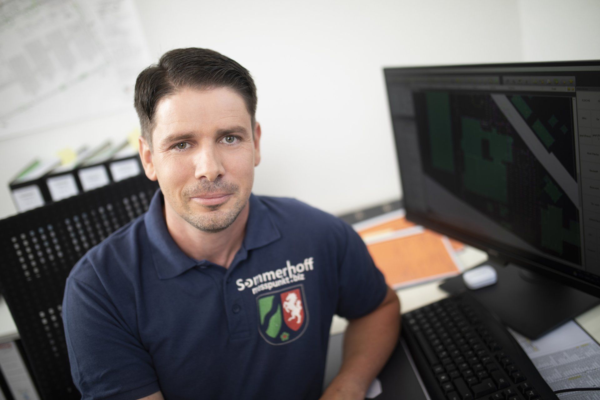 Ein Mann sitzt an einem Schreibtisch vor einem Computer.