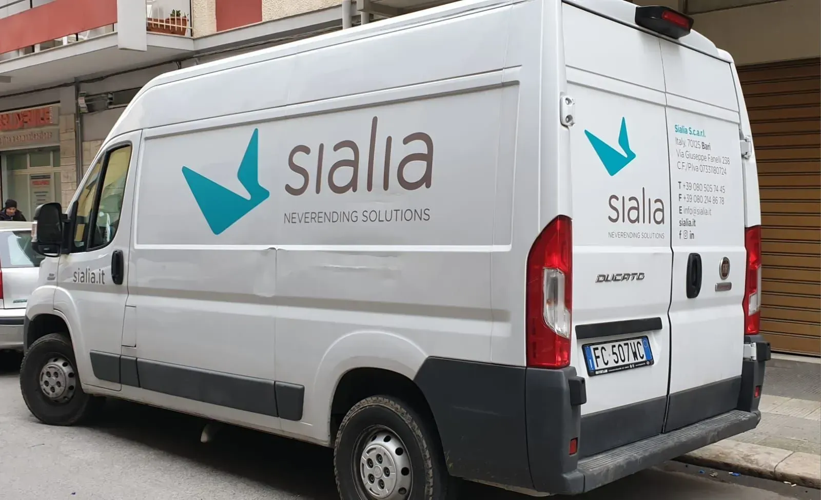 Furgone bianco della Sialia parcheggiato in strada, con logo e scritta blu sul lato.
