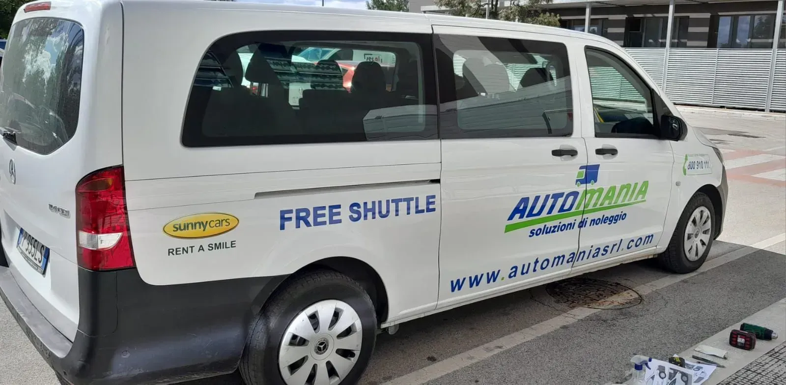 Un furgoncino bianco adibito a navetta aeroportuale con le scritte