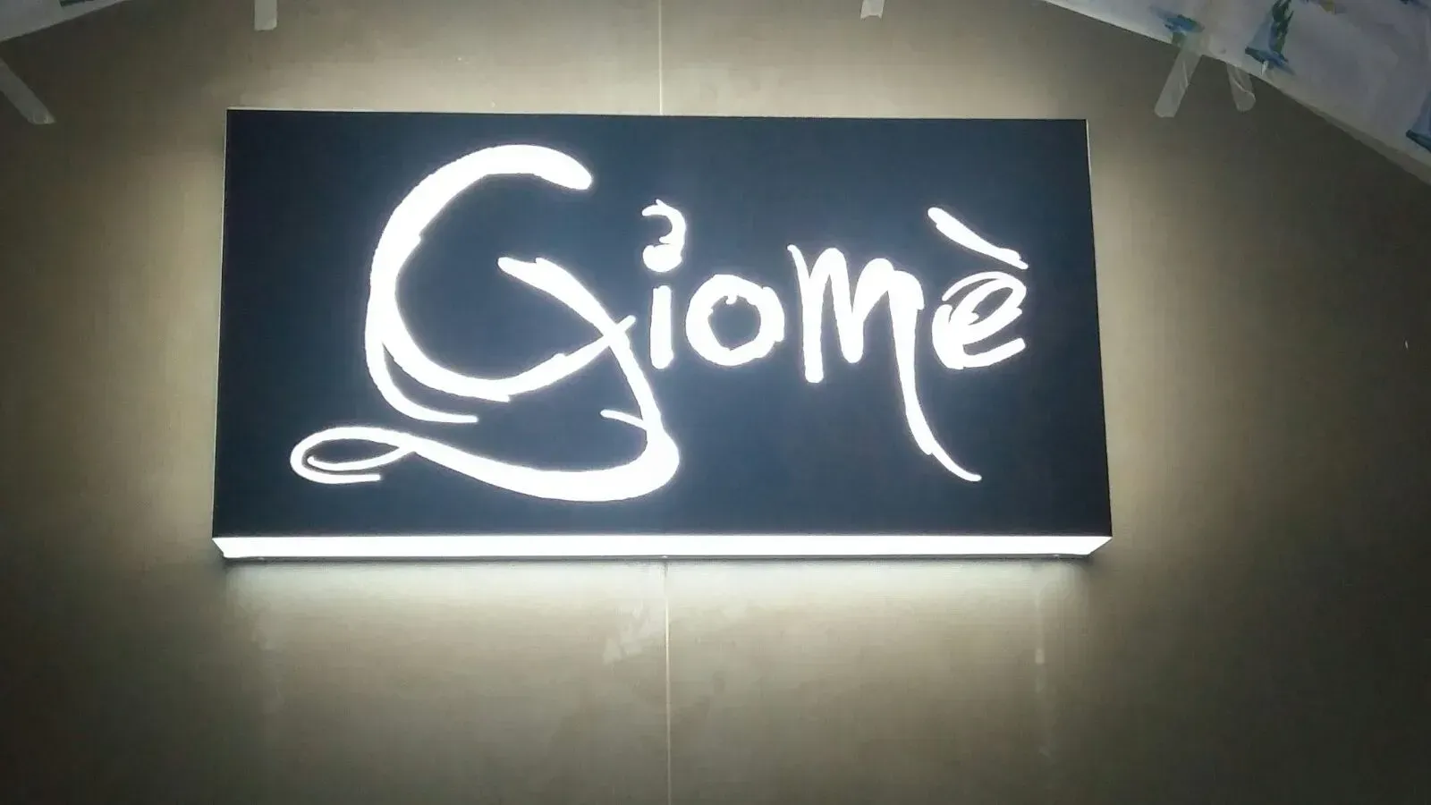 Insegna nera illuminata con scritta bianca 