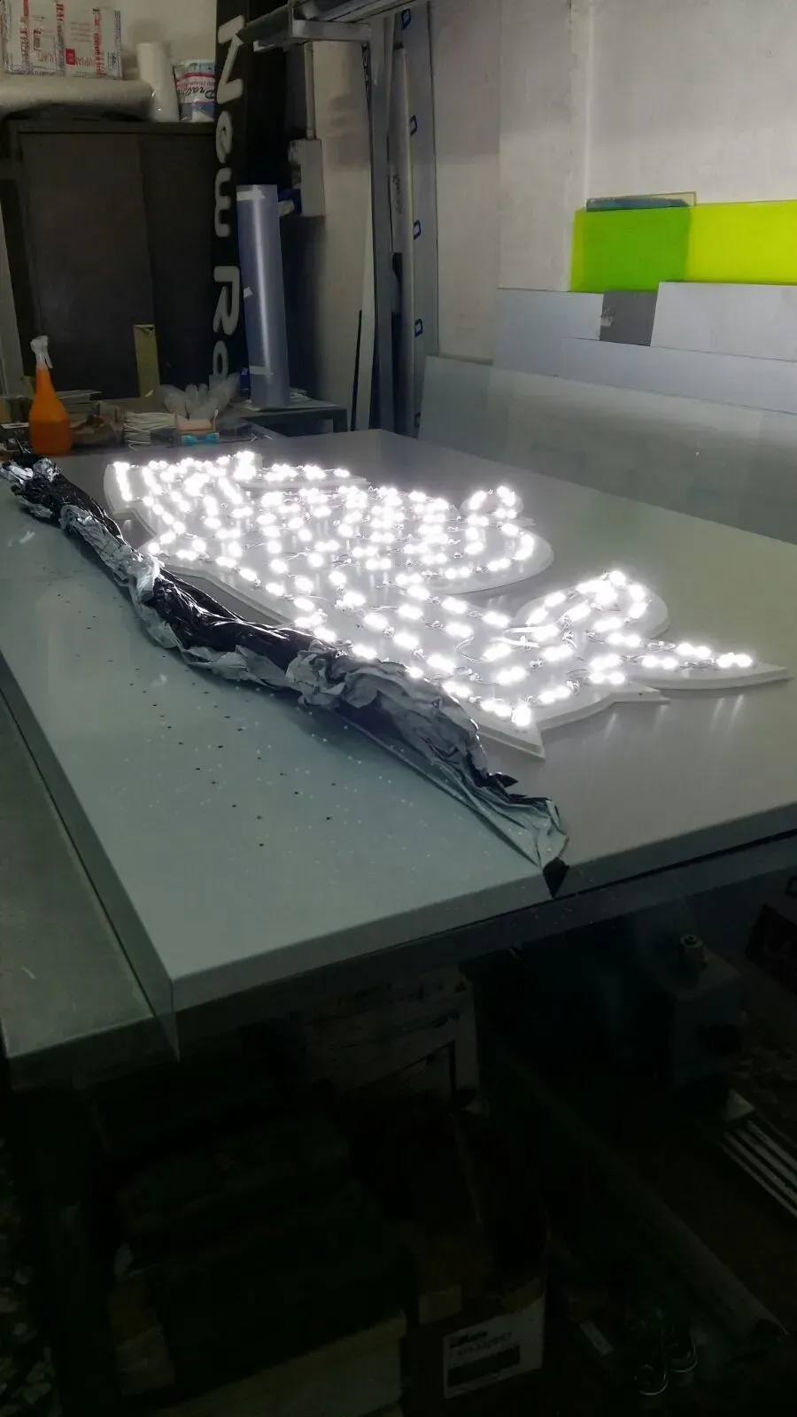 Luci LED brillanti disposte su un tavolo in una stanza simile a un'officina.