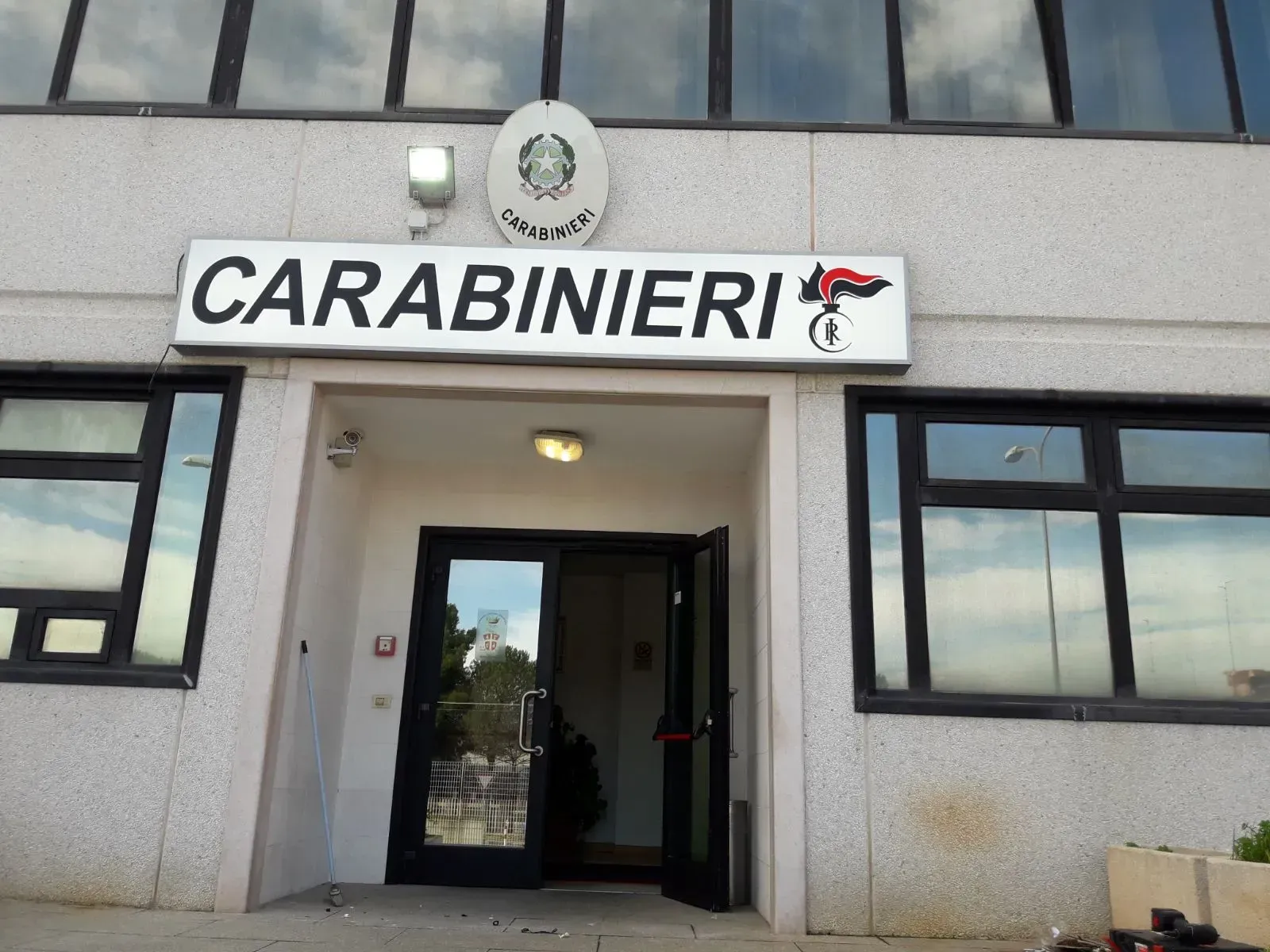 Ingresso della stazione dei Carabinieri con insegna sopra la porta e finestre su entrambi i lati