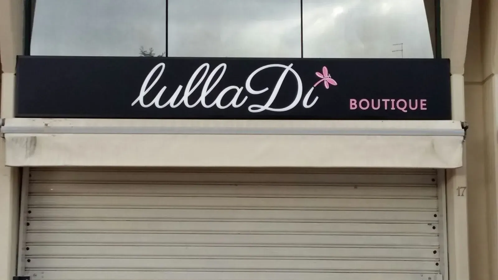 LullaD insegna della boutique sopra una serranda bianca chiusa.
