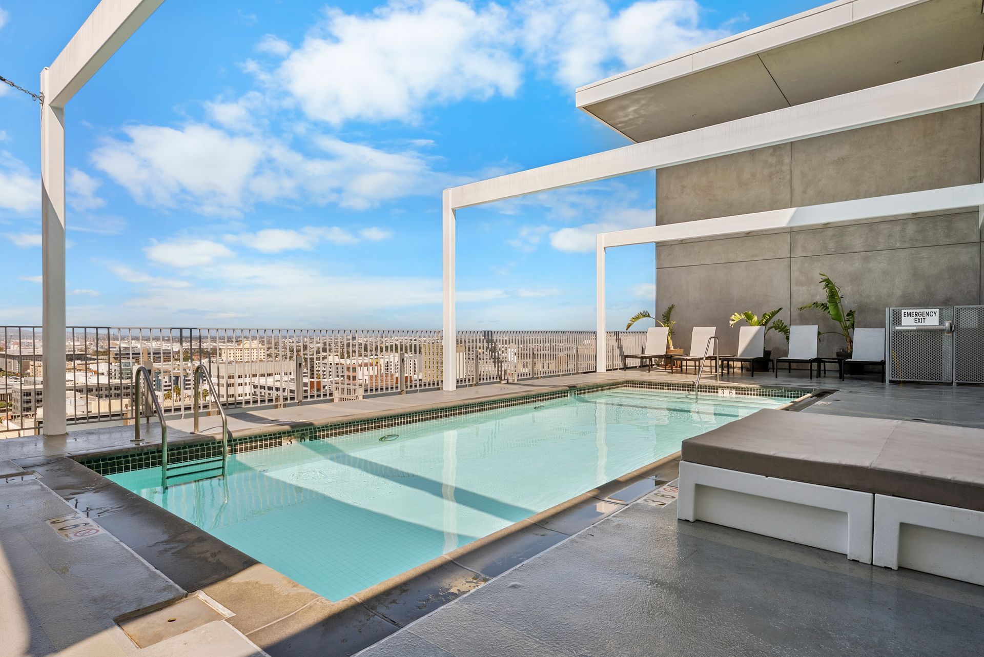 pool with lounge chairs and view of skyline