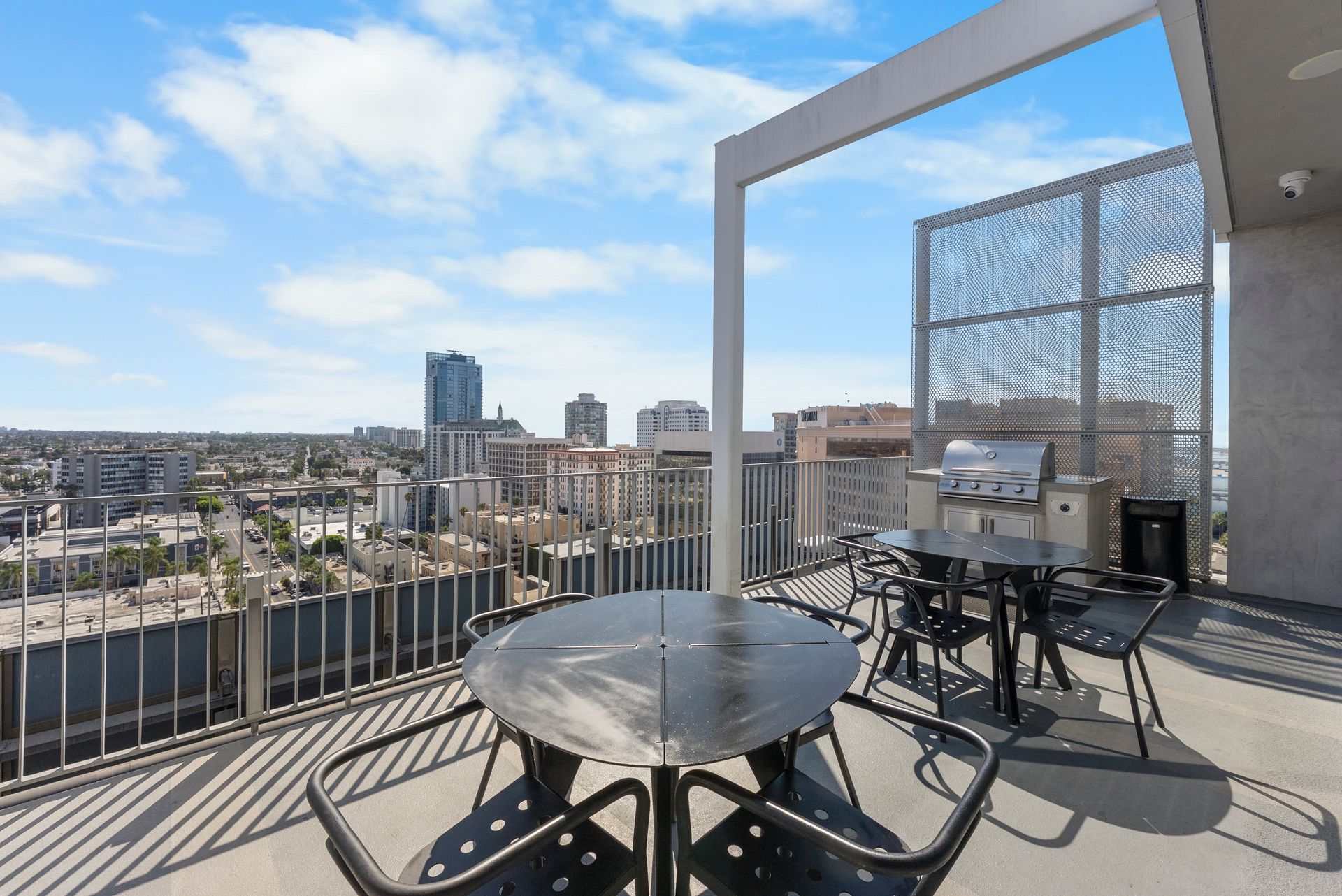 patio tables, bbq grill, and view of skyline