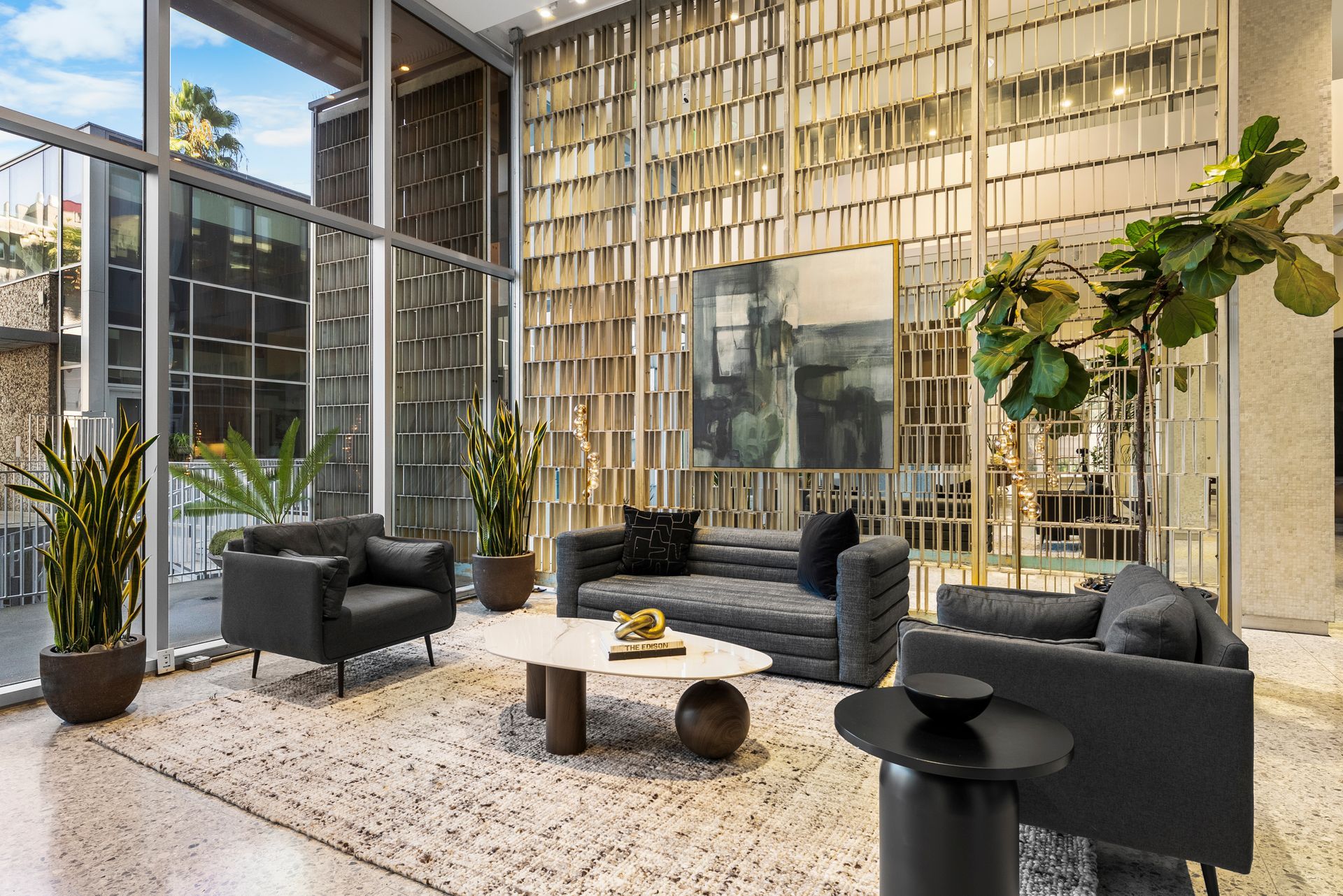geometric wall with black couches and table
