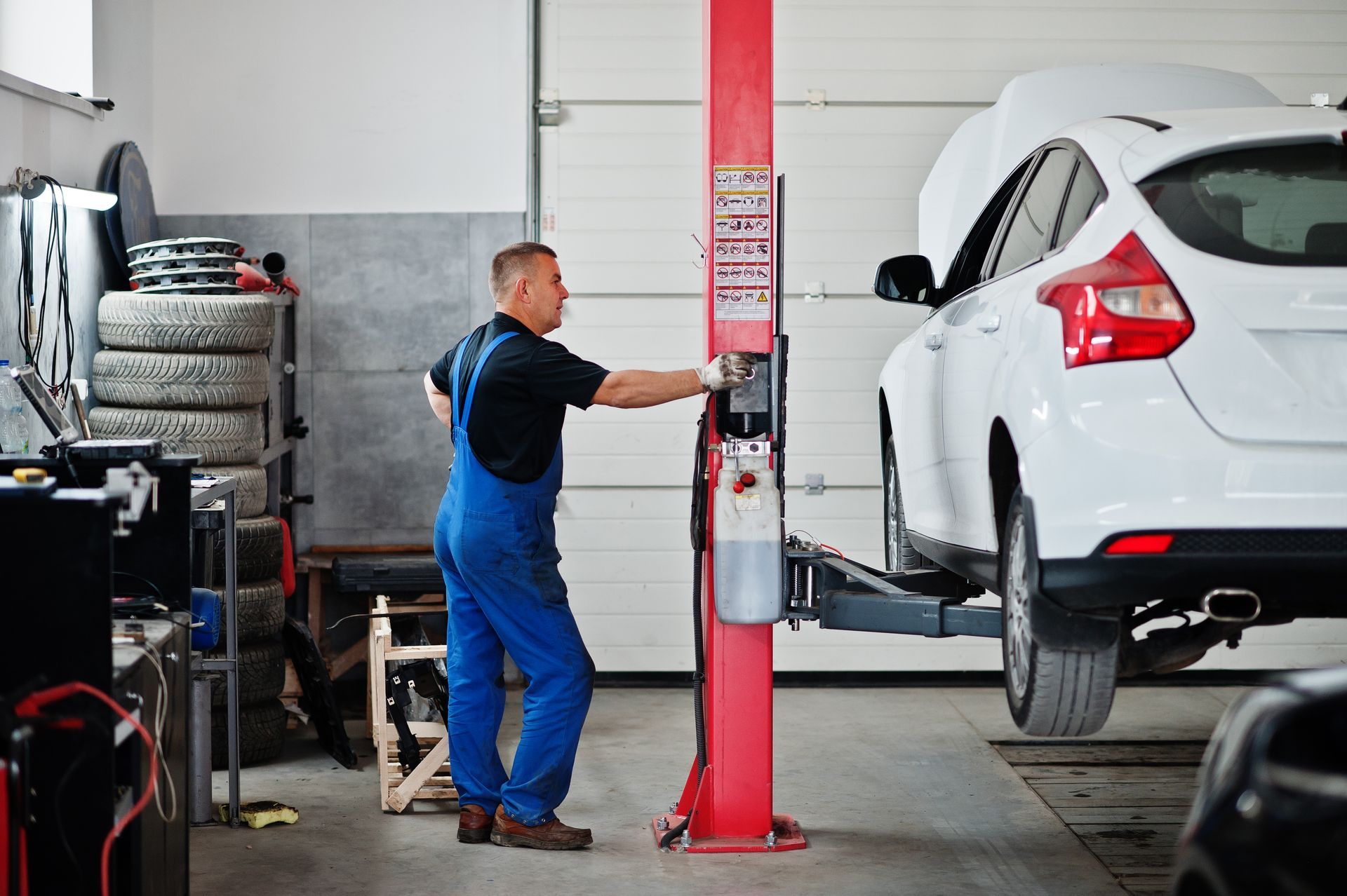 a man is working on a white car in a garage