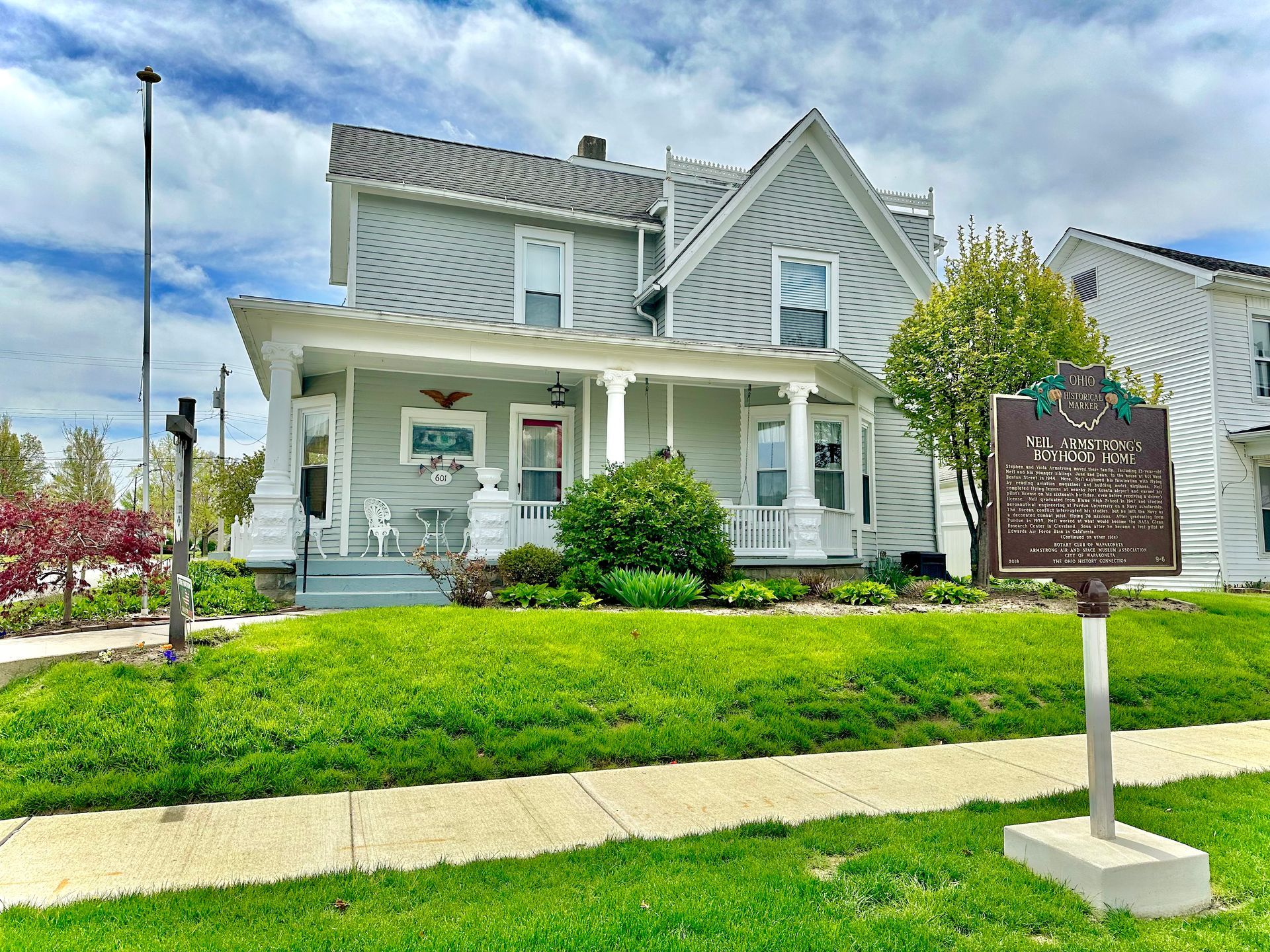 A large gray house with a porch and stairs. This was Neil Armstrong's family home.