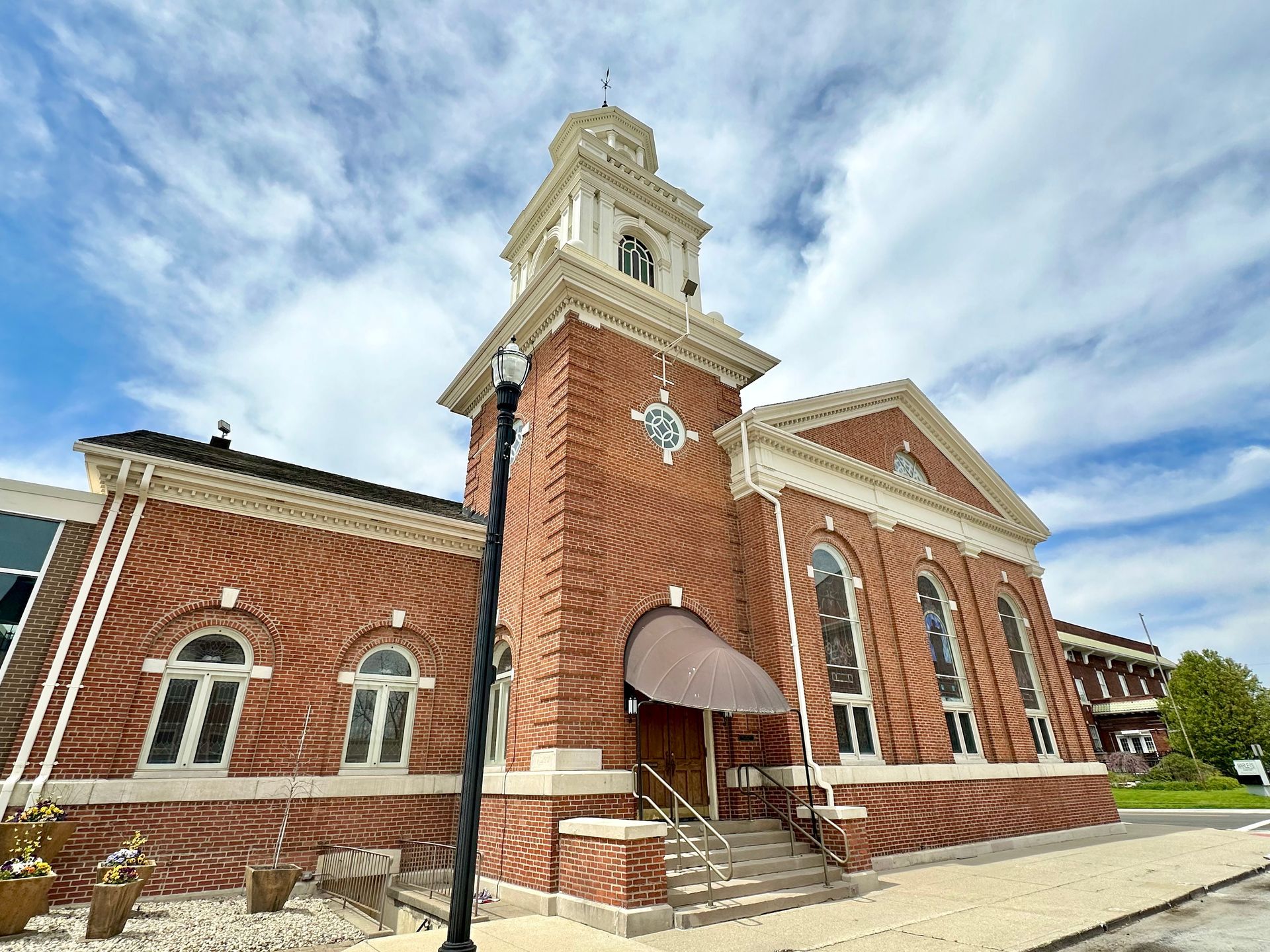 The St. Paul United Church of Christ is a brick building with a high steeple.
