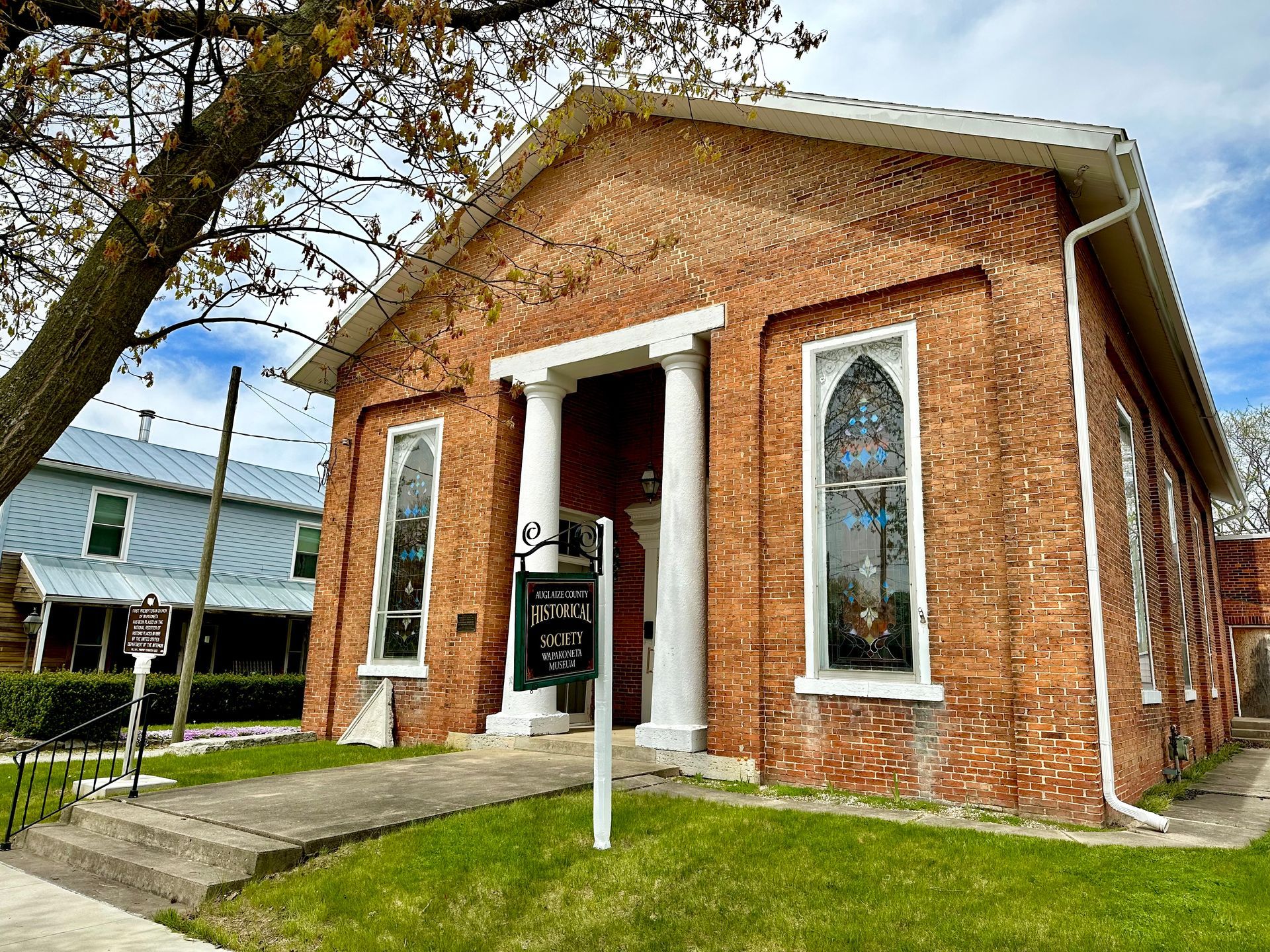 The Wapakoneta Museum, with white columns and a tree in front of it.