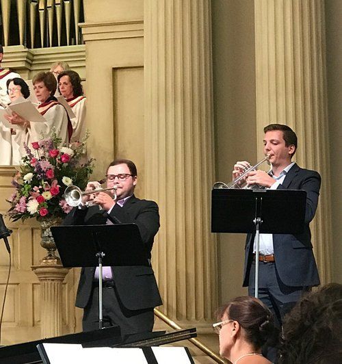 A group of men are playing trumpets in a church
