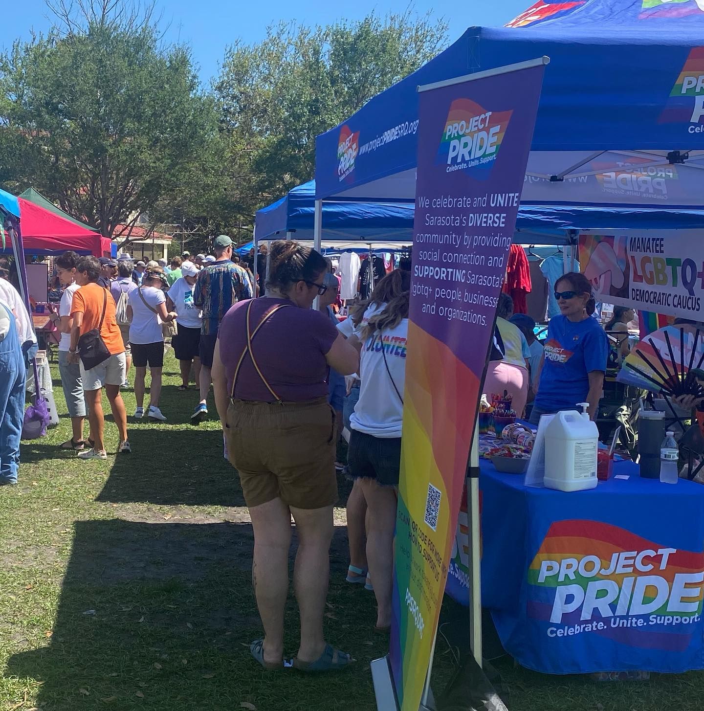 A group of people standing around a table that says project pride