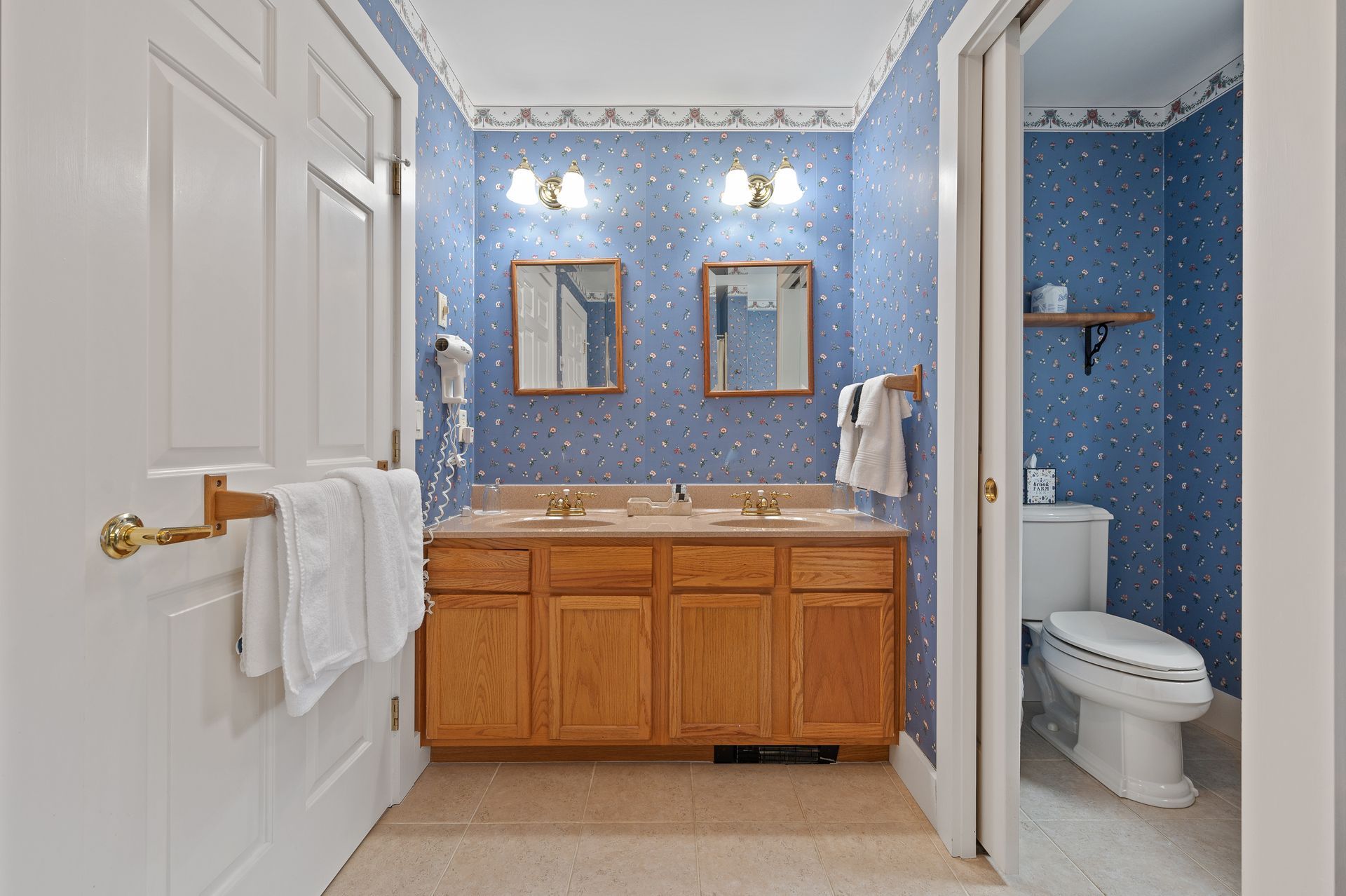A bathroom with two sinks and a toilet.