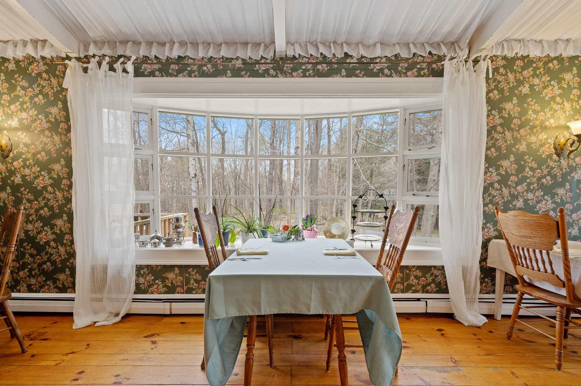 A dining room with a table and chairs and a large window